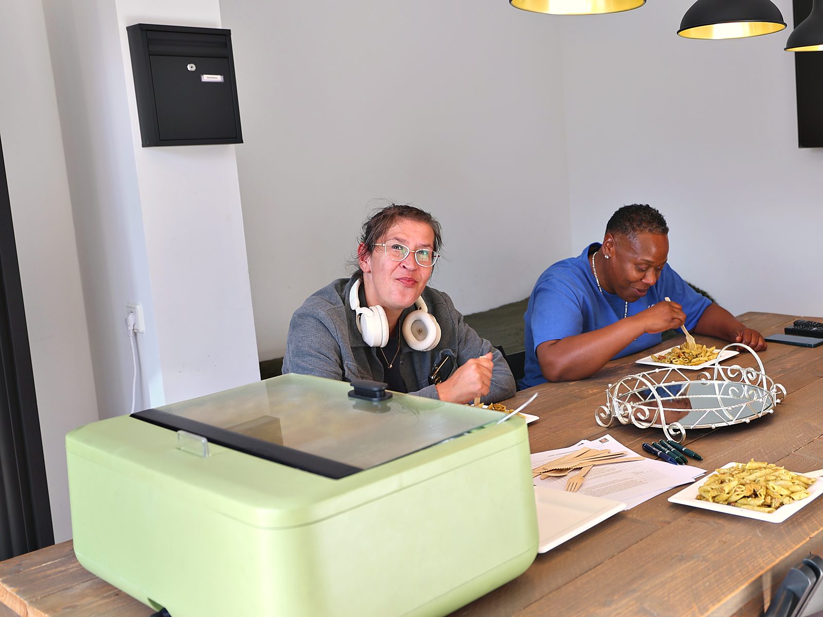 Cliënten eten samen aan tafel in de gezamenlijke woonkamer van GG-Zorg